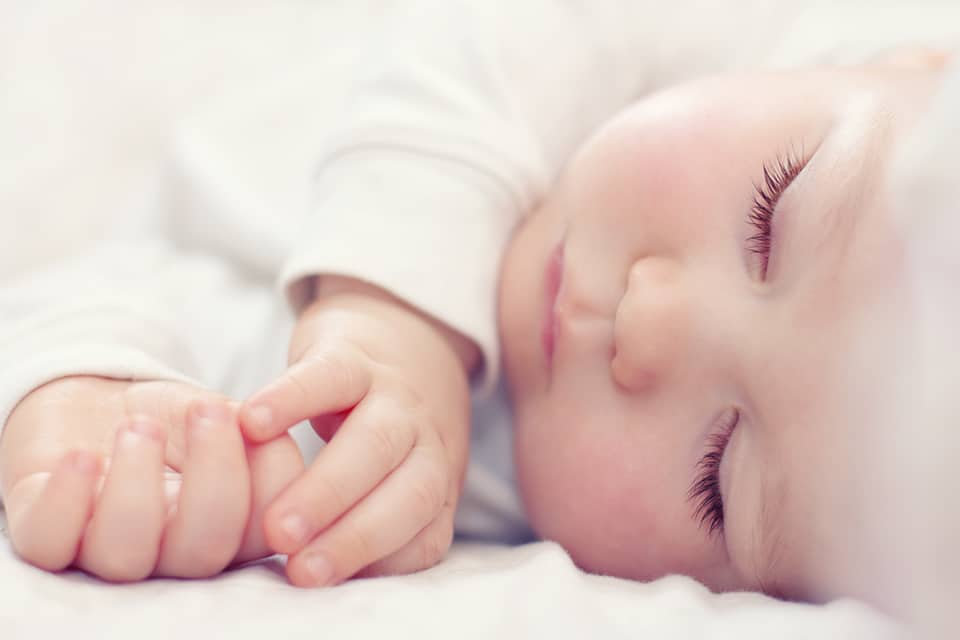 close-up portrait of a beautiful sleeping baby on white Kinder geboren nach IVF Behandlung